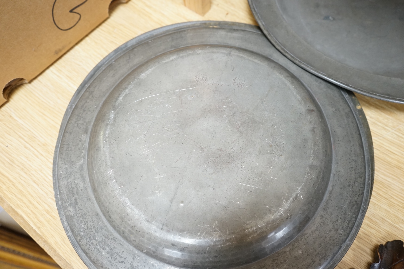 Three Pewter chargers, a large dish and a plate, c.1800, largest dish 42cm diameter (5)